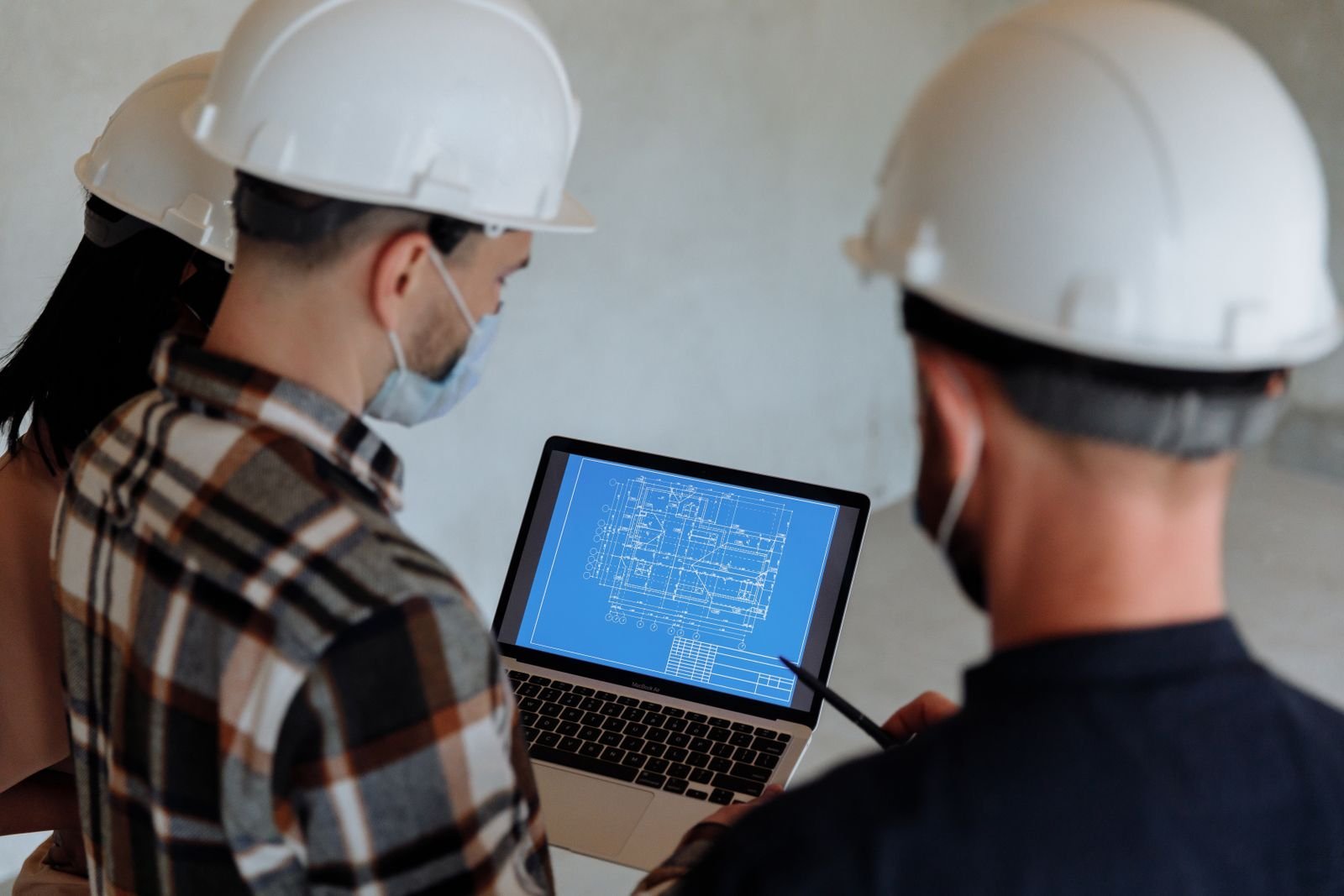 People in Hard Hats Looking at a Blueprint