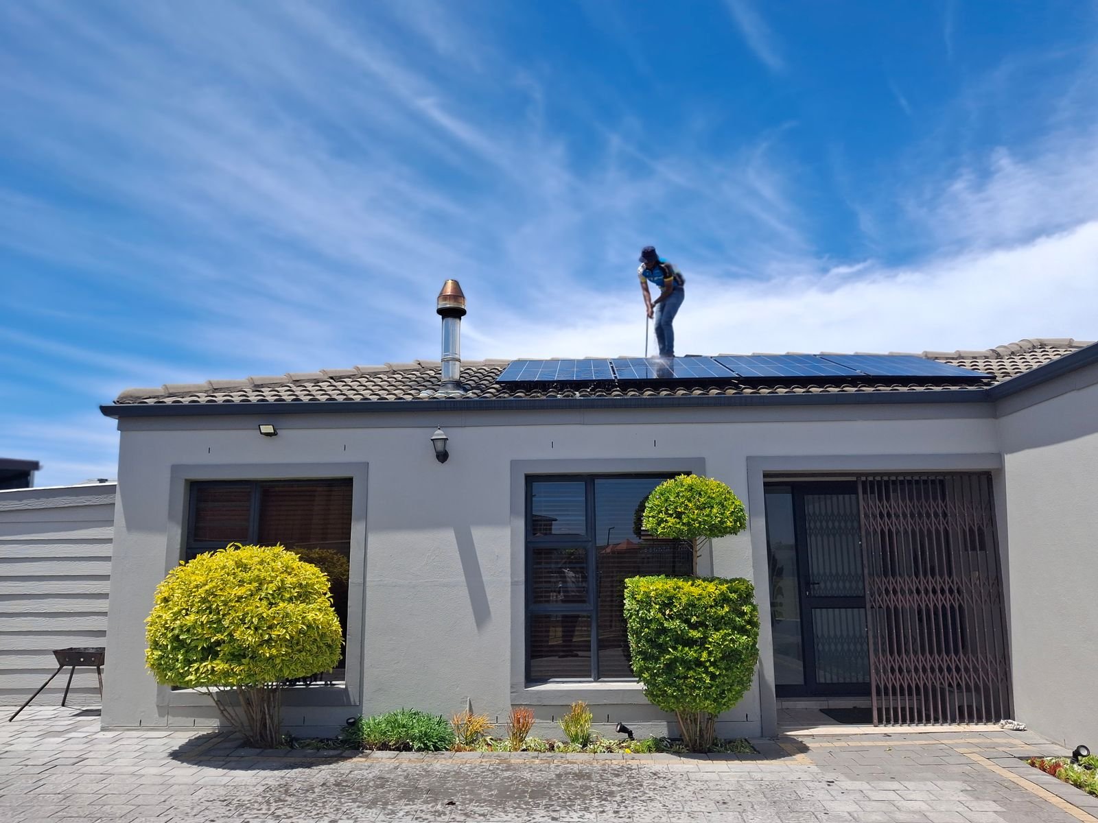 Technician Installing Solar Panels on Villa Roof