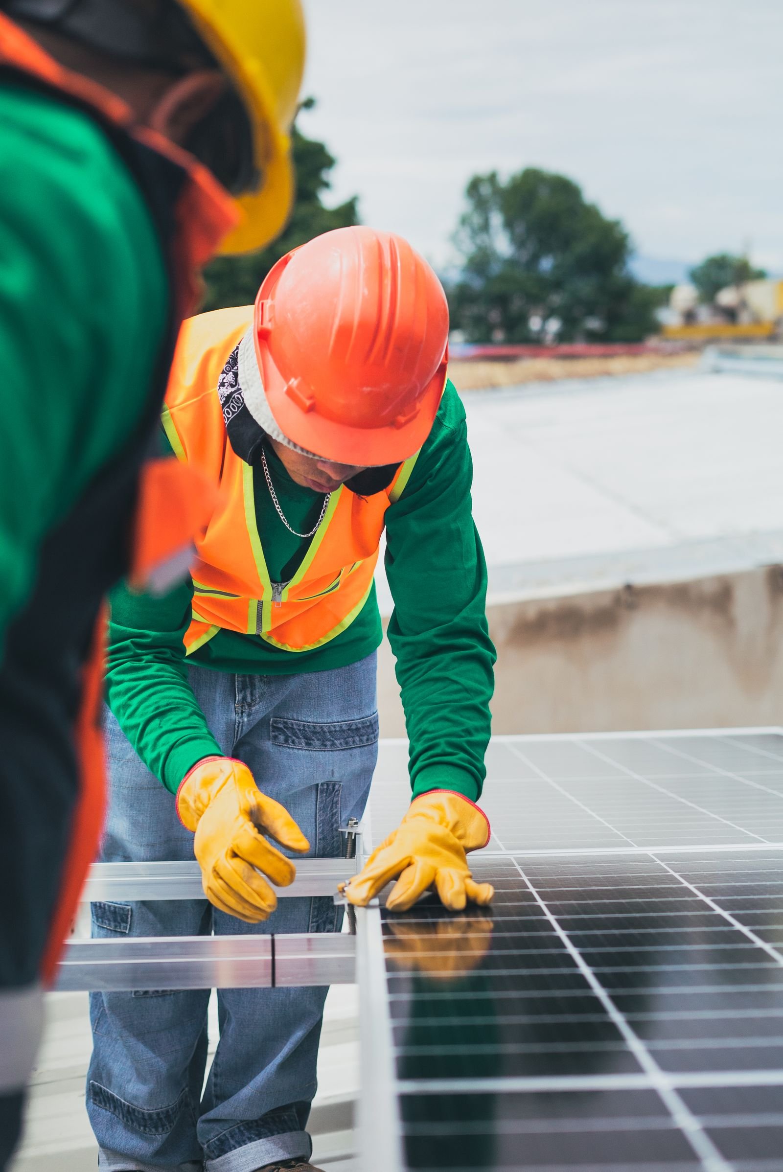 Solar Technician in Safety Gear Installing Panels